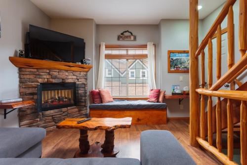 Una sala de estar con chimenea y televisión. en BigWhite Ski In-Out Chalet w Priv HotTub & Garage, en Big White
