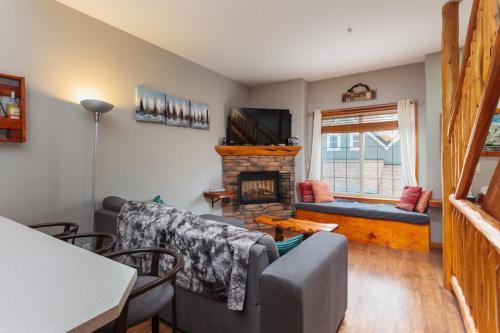 a living room with a couch and a fireplace at BigWhite Ski In-Out Chalet w Priv HotTub & Garage in Big White