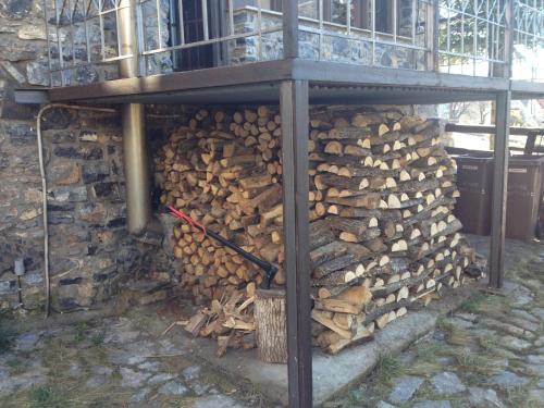 a pile of fire wood under a building at Chalet Asteras tou Vorra in Palaios Agios Athanasios