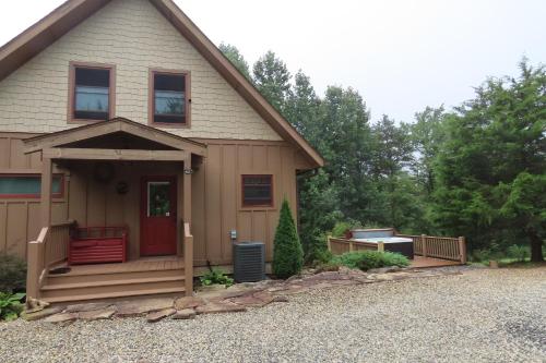 a house with a red door and a porch at Cozy Couples Getaway with Hot Tub Fox Ridge Cabin in Whittier