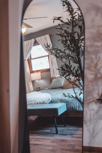 a bedroom with a bed and a mirror at Bigfoot's Hideout - A Hocking Hills Escape in Logan