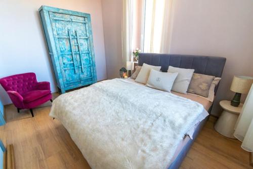 a bedroom with a large bed and a red chair at Unique apartment in Ratibor in Racibórz
