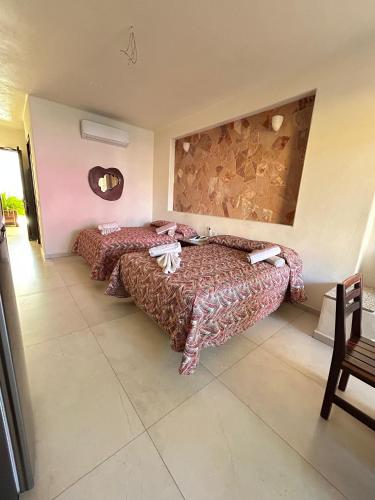 une chambre avec deux lits et un miroir dans l'établissement AMPARO RESORT, à Los Ayala