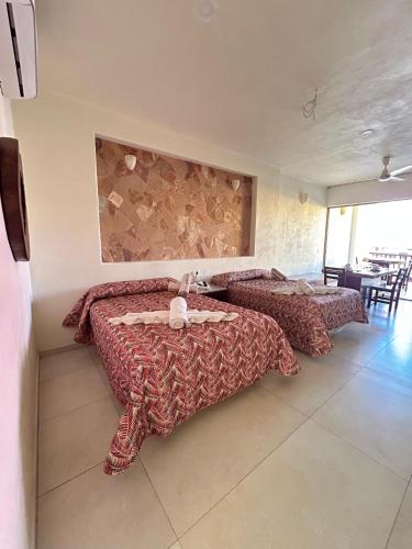 une chambre avec deux lits et une table et des chaises dans l'établissement AMPARO RESORT, à Los Ayala