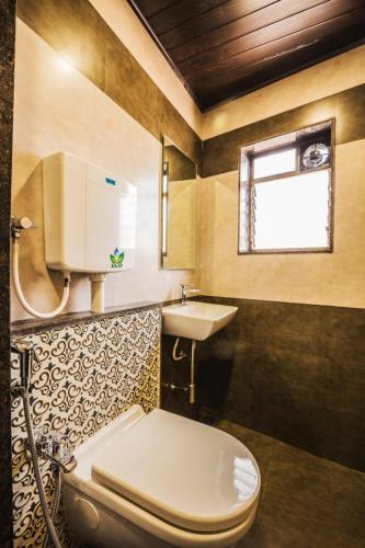 a bathroom with a toilet and a sink at Hotel Golden Crown in Mumbai