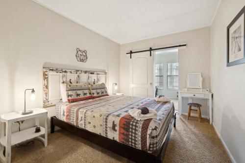 a white bedroom with a bed and a window at Superb Gatlinburg Condo with Pool Table and private balcony with stream views in Gatlinburg