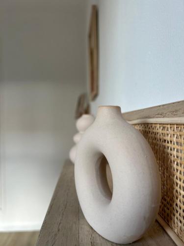 a white vase sitting on top of a wooden table at Chez le Grand in Maraussan
