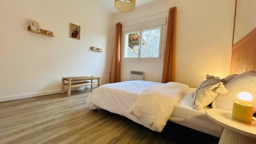 a bedroom with a bed and a window at Chez le Grand in Maraussan