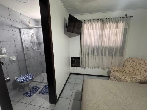 a bedroom with a bathroom with a toilet and a shower at A55 - Casa centro de Bombinhas in Bombinhas