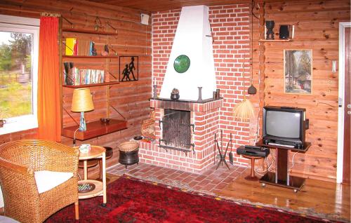 a living room with a fireplace and a tv at Kanalhytten in Rømø Kirkeby
