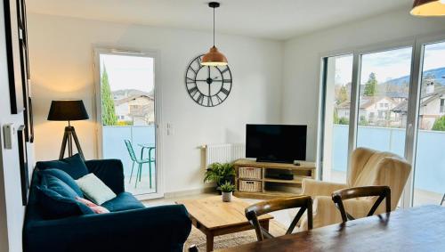 a living room with a blue couch and a table at Sweet & Charm for this cozy appt in Saint-Julien in Saint-Julien-en-Genevois