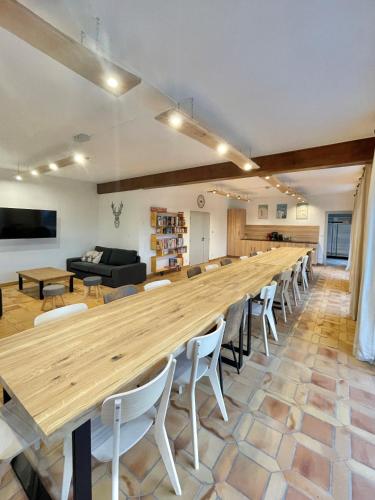 une grande table en bois dans une chambre avec des chaises dans l'établissement Gîte 15 personnes Sauna et Spa, à Le Thillot