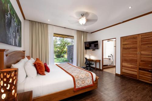 a bedroom with a bed and a large window at Hacienda Guachipelin Volcano Ranch Hotel & Hot Springs in Liberia