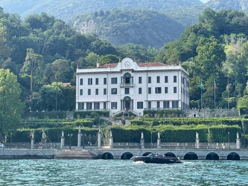 a boat in the water in front of a white building at BELLE ILE PARK in Griante Cadenabbia