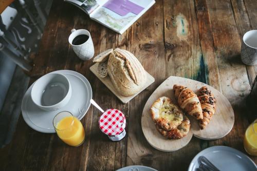 a wooden table with bread and a plate of food at Llanfair Hall, Dog Friendly, Cinema, Games Room, Hot Tub in Llanfairpwllgwyngyll