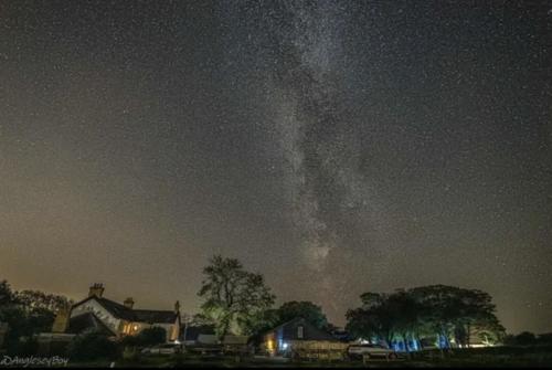 a starry night with a milky way in the sky at Llanfair Hall, Dog Friendly, Cinema, Games Room, Hot Tub in Llanfairpwllgwyngyll