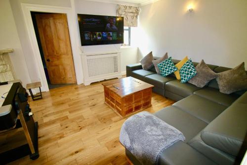 a living room with a couch and a coffee table at Llanfair Hall, Dog Friendly, Cinema, Games Room, Hot Tub in Llanfairpwllgwyngyll