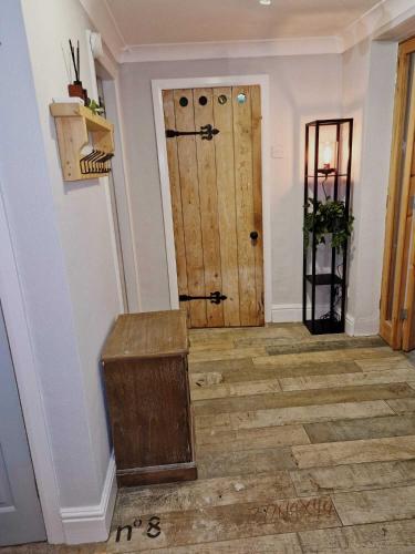 a hallway with a door and a wooden floor at Llanfair Hall, Dog Friendly, Cinema, Games Room, Hot Tub in Llanfairpwllgwyngyll