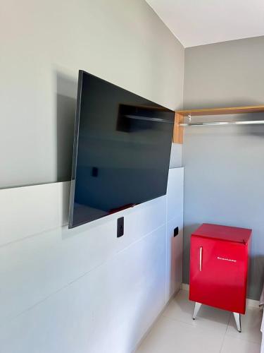 a room with a tv and a red stool at Santa Rita Pousada in Guarujá