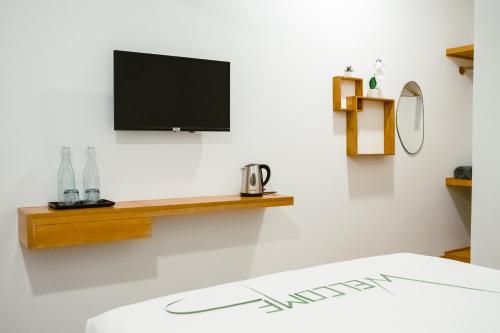 a room with a tv on a wall with a bed at Island Serenity in Dhiffushi