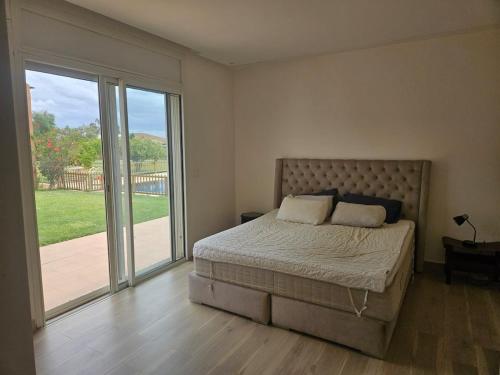 a bedroom with a bed and sliding glass doors at premium farmhouse with pool Rabat in Rabat