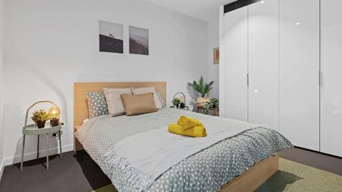 una camera da letto con un letto con un cappello giallo di The Downtown Nest a Melbourne