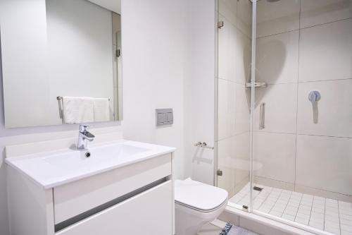 a white bathroom with a sink and a shower at 8's at Ellipse Waterfall in Midrand