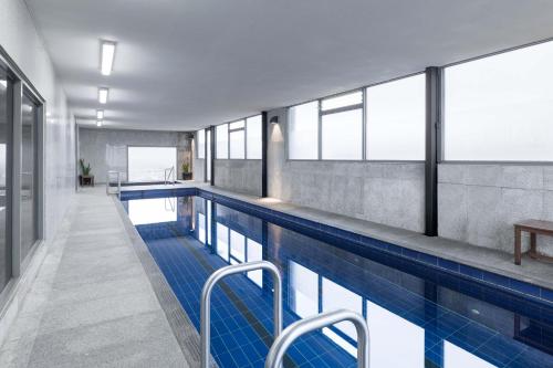 a large swimming pool with blue tiles and windows at Mantra Melbourne Airport in Melbourne
