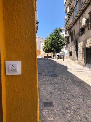 a yellow wall with a sign on a street at La Casa de la Abuela in Jaén