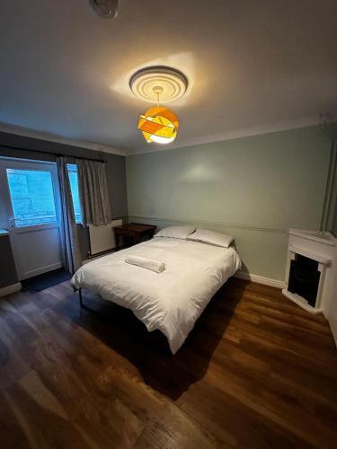 a bedroom with a large white bed with a light at Detached 4BR, 4 Bathroom, Driveway, WiFi, Smart TV in Napton on the Hill