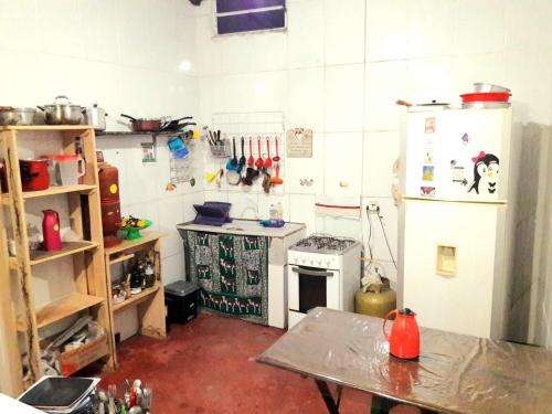 a kitchen with a refrigerator and a table in it at Casa da Pri em São Jorge in Sao Jorge