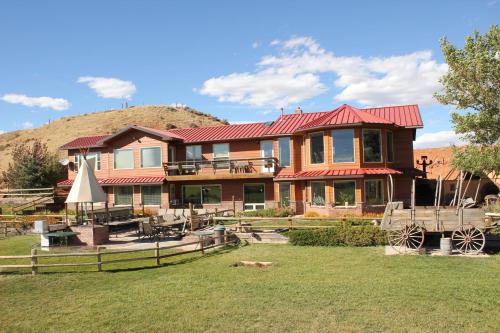 a large house with a hill in the background at K3 Guest Ranch in Cody