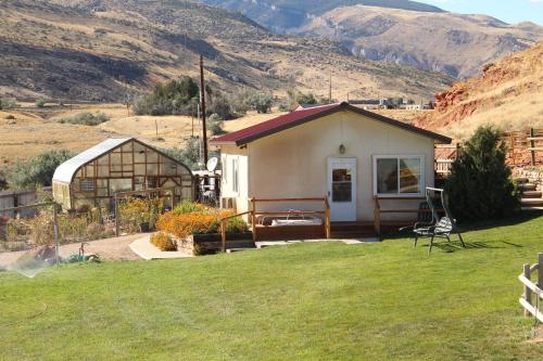 a small house in a field with mountains in the background at K3 Guest Ranch in Cody