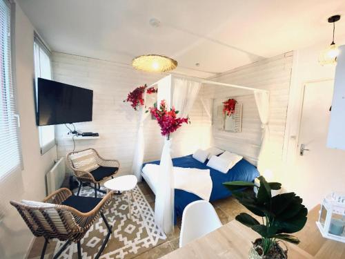 une petite pièce avec un lit, une table et des chaises dans l'établissement Bienvenue à Santorin - Caen centre, à Caen