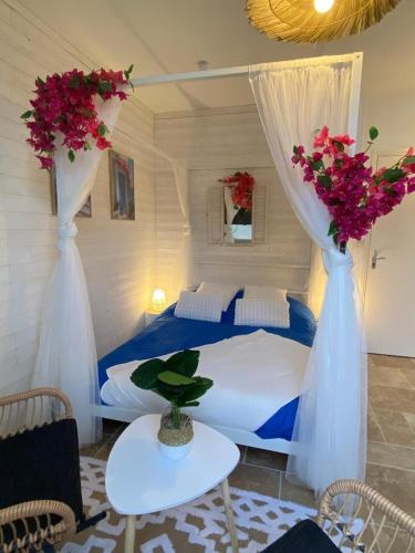 une chambre avec un lit avec deux vases avec des fleurs dans l'établissement Bienvenue à Santorin - Caen centre, à Caen