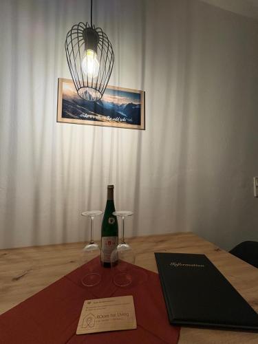 a bottle of wine on a table with two glasses at Modernes Serviced Apartment - FeWo Morgenglanz in Berchtesgaden