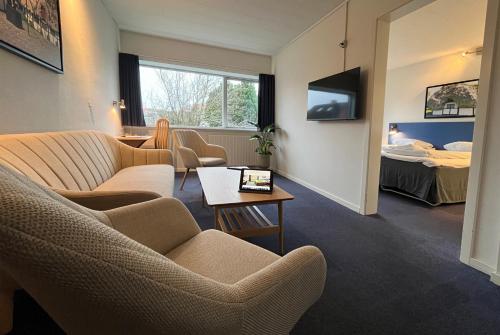 a hotel room with a couch and chairs and a table at BB-Hotel Frederikshavn Turisthotellet in Frederikshavn