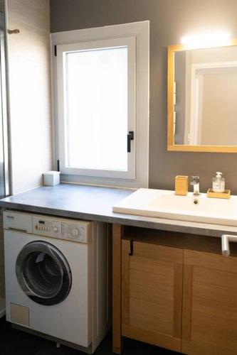une salle de bain avec une machine à laver et un lavabo dans l'établissement Chez Sophie Appartement T2 Gare Saint Jean, à Bordeaux