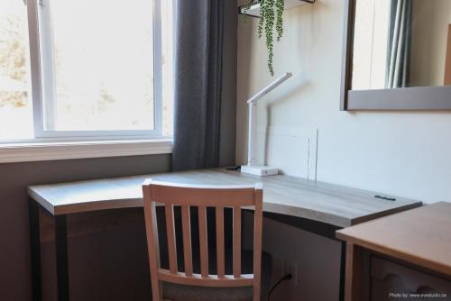 a desk with a chair and a lamp in a room at Entire Lovely Townhouse Mountain View! in Canmore