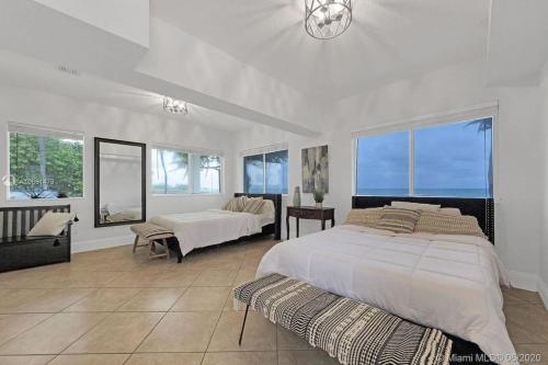 a large white bedroom with two beds and a window at Oceanfront Villa On Semi-Private Holywood Beach in Hollywood