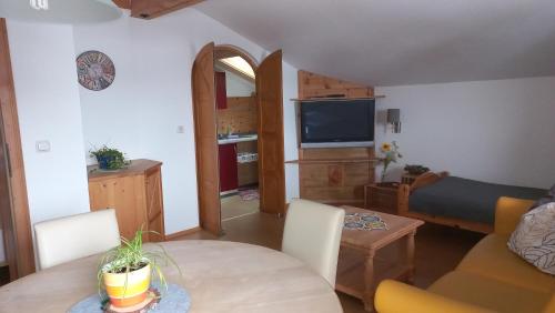 a living room with a table and a couch and a television at Chalet Glücklich sein... in Ellmau