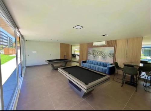 a living room with a couch and a pool table at Loft em Xangri-Lá com piscina aquecida in Xangri-lá