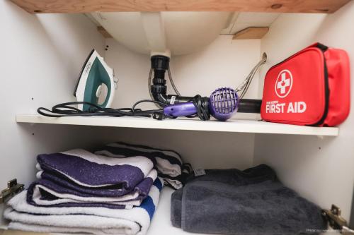 a closet with a first aid bag and towels at Entire Lovely Townhouse Mountain View! in Canmore