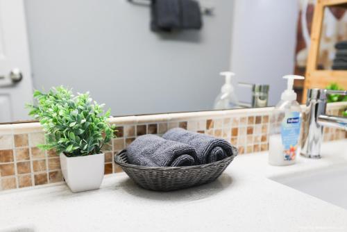 a basket of towels on a counter next to a sink at Entire Lovely Townhouse Mountain View! in Canmore