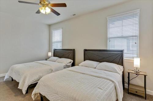 two beds in a bedroom with a ceiling fan at Modern W Pool, Gym, HotTub, Golf, Pet Friendly in Draper