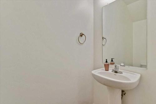 a white bathroom with a sink and a mirror at Modern W Pool, Gym, HotTub, Golf, Pet Friendly in Draper