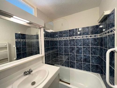 une salle de bain avec un lavabo, une baignoire et un miroir dans l'établissement Résidence Le Vignemale - Appartement Résidence VIGNEMALE à deux pas du centre MAE-6124, à Saint-Lary-Soulan