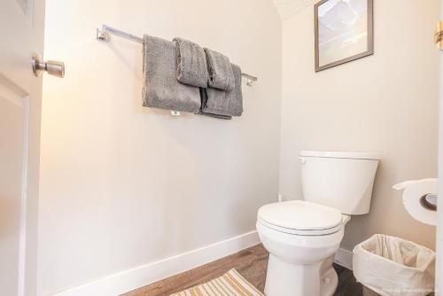 a bathroom with a white toilet and towels at Entire Lovely Townhouse Mountain View! in Canmore
