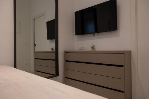 a bedroom with a dresser with a tv on the wall at Baštun & Dujka's balatura in Split