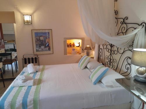 a bedroom with a large white bed with blue pillows at Calergi Residence - Holidays in Crete in Atsipopoulo